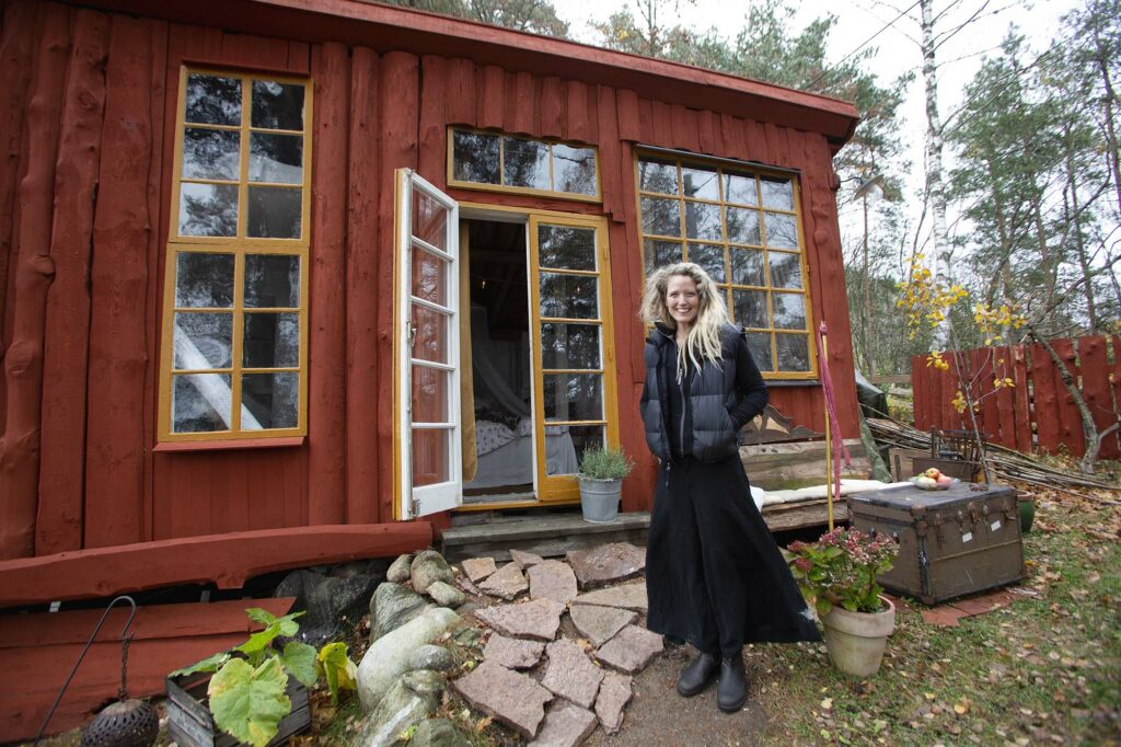 Kvinna framför rött hus