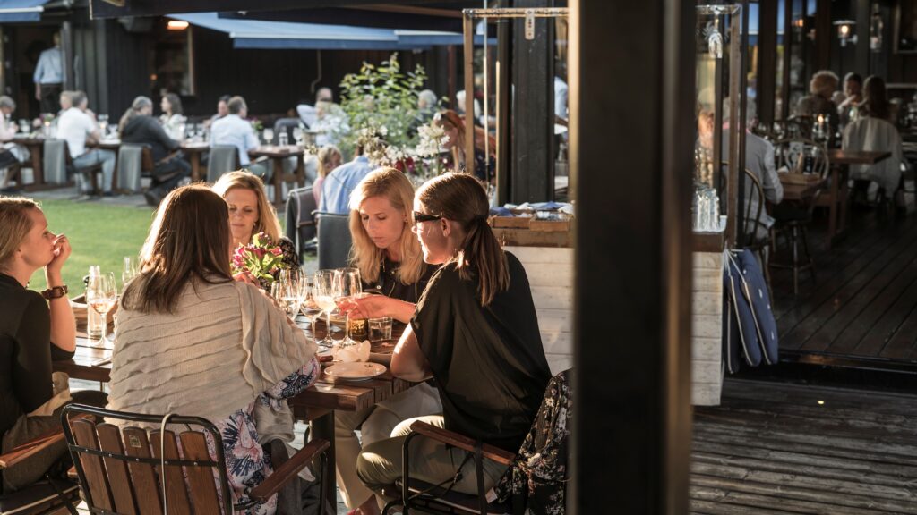 Personer sitter vid bord och äter