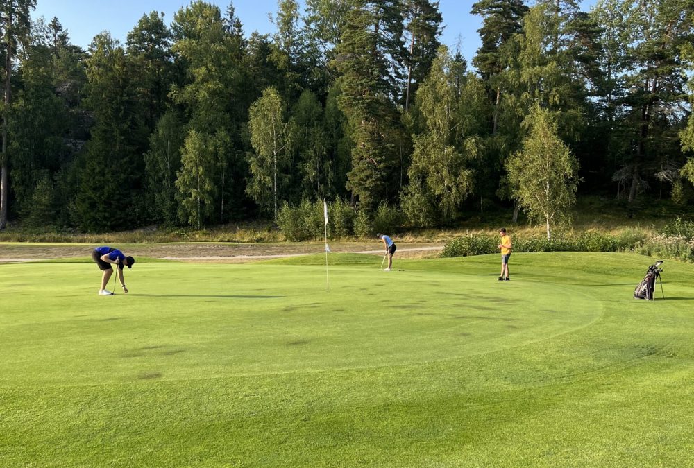 Tre spelare på en golfbana.